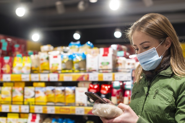 woman-wearing-face-mask-shop-looking-her-phone_23-2148480492